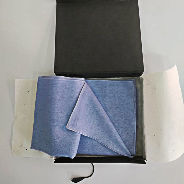 Men's blue cashmere scarf neck wrap wrapped in a hand-made tissue and kept in a hard-covered paper box for shipping.