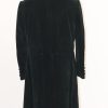 Full back view of the green velvet frock coat on a stand with the back seam, vent, and skirt design details.