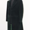 Full side view of the green velvet frock coat on a stand with the sleeve position, cuffs, and button details.